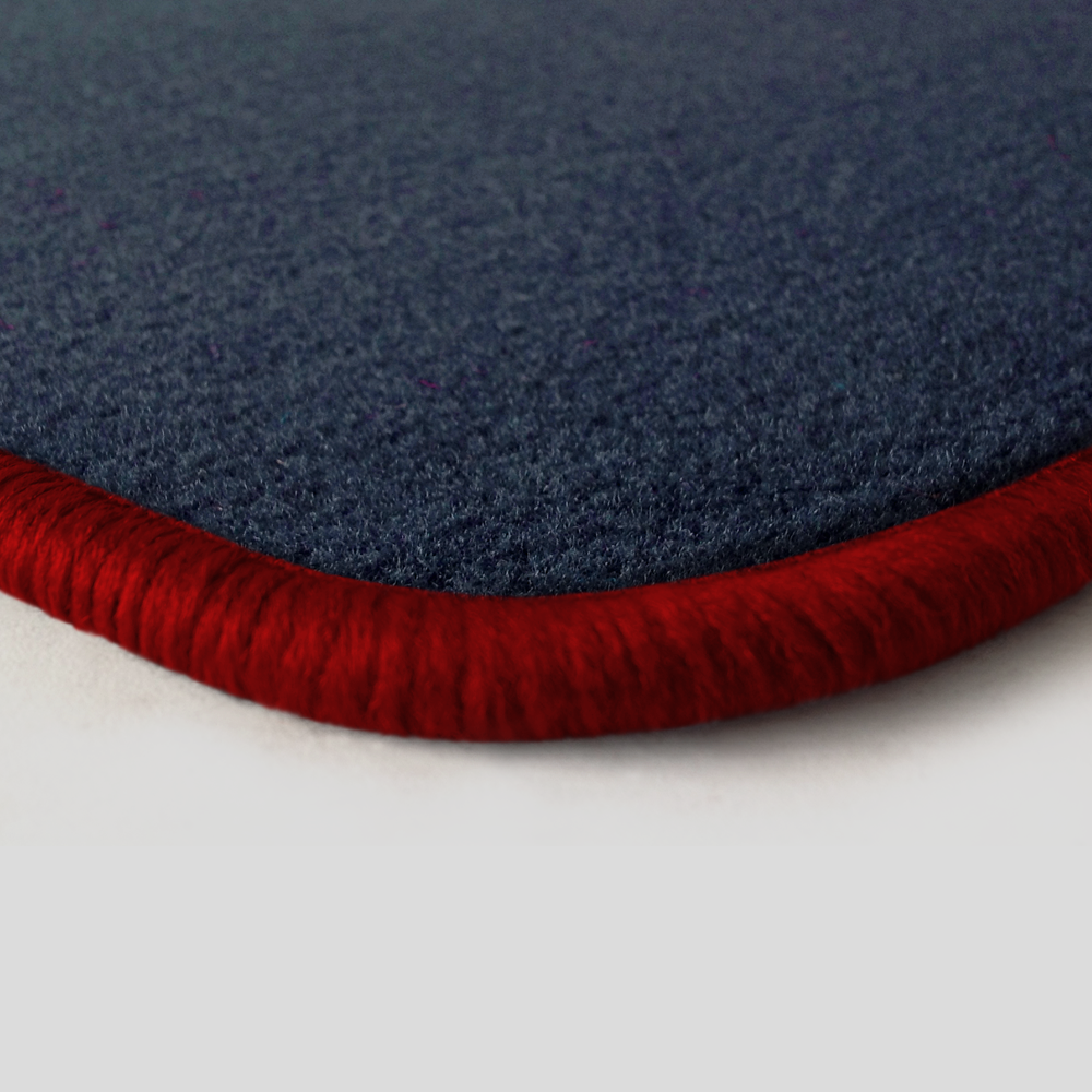 Eine Ecke als Beispiel einer Fussmatte Velours dunkelblau mit Rand in rot.
