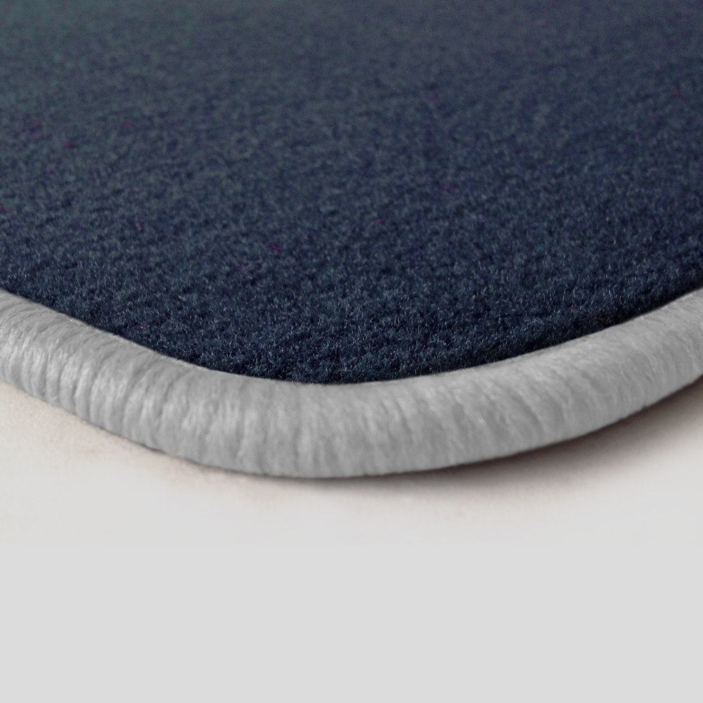 Eine Ecke als Beispiel einer Fussmatte Velours dunkelblau mit Rand in weiss.